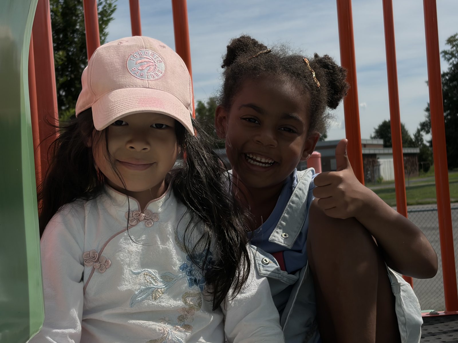 Two smiling campers wearing caps outdoors at Laurus Summer Camp