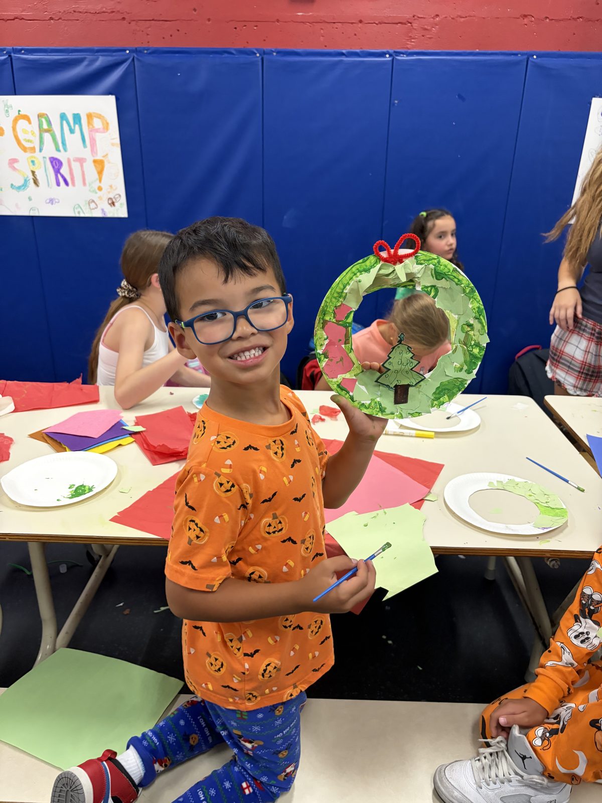 Young camper making a colourful craft at a table during a hands-on kids activity