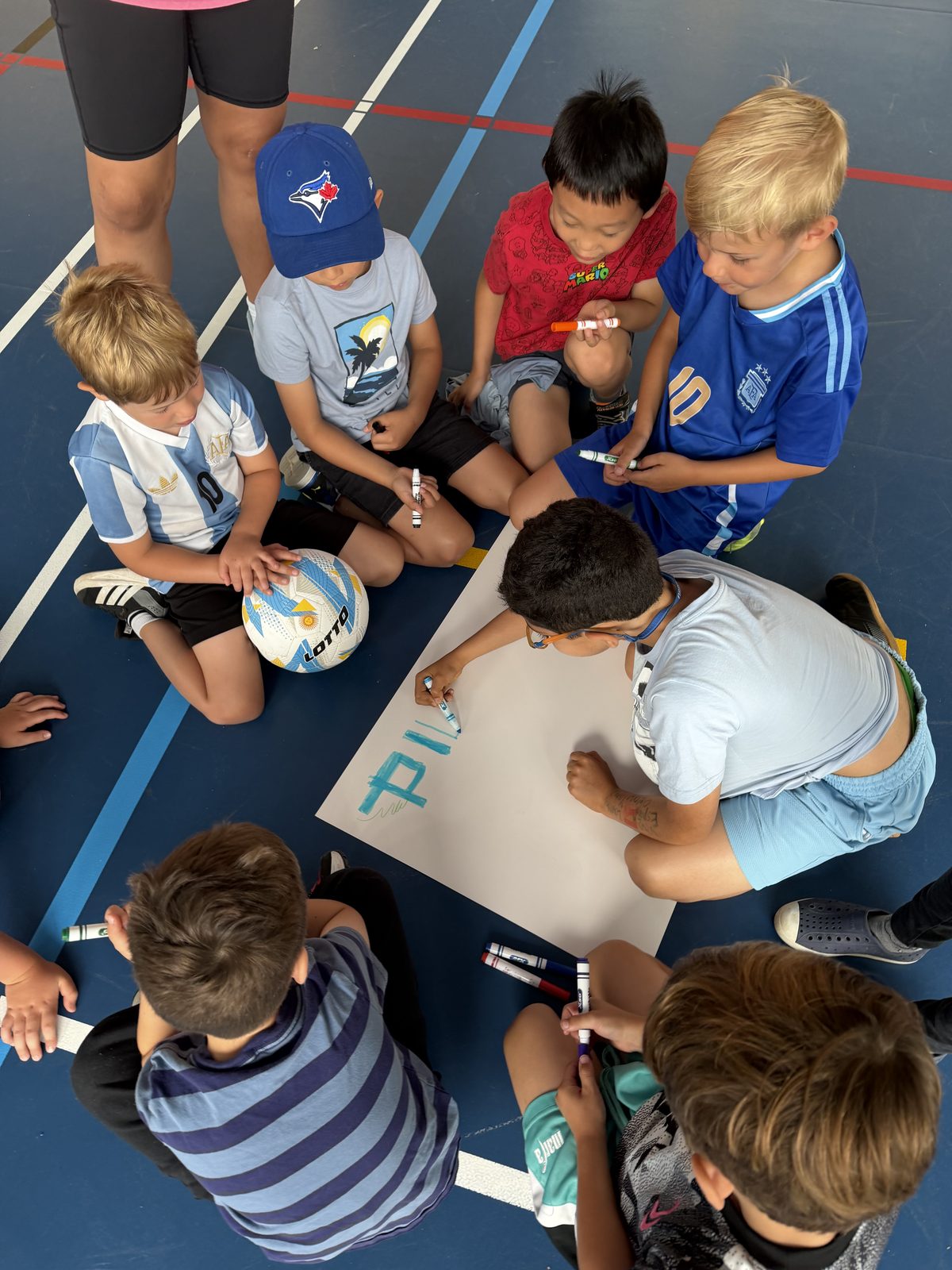 Campers gathered around a table during a hands-on group activity at Laurus Summer Camp